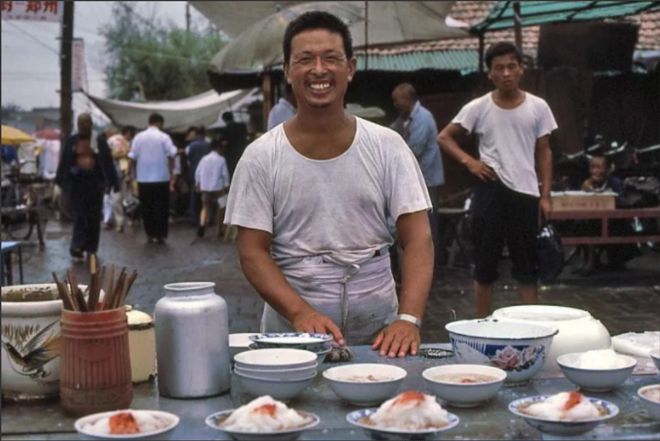 1983年开封一位摆摊售卖凉皮的大哥餐具上很有时代特色！(图1)